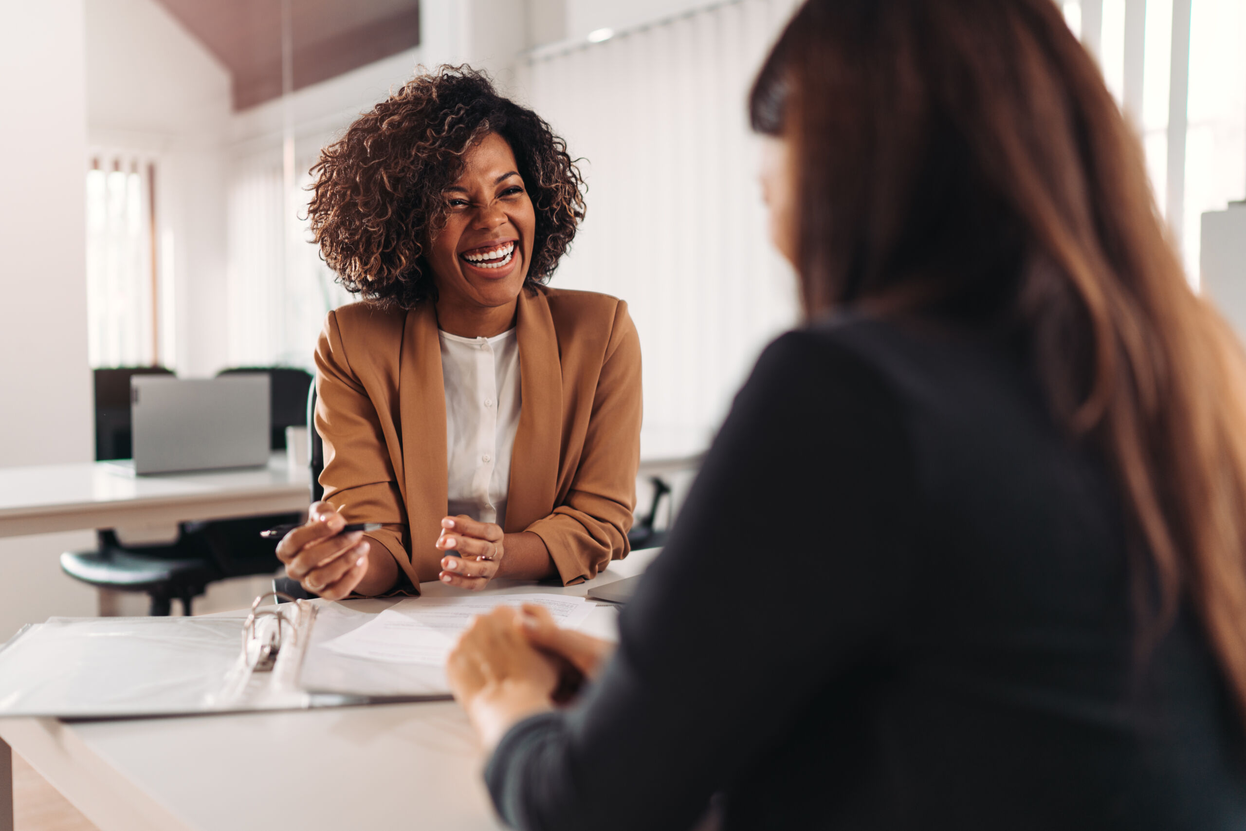 Female realtor consulting a client at the meeting and having business conversation or making offer